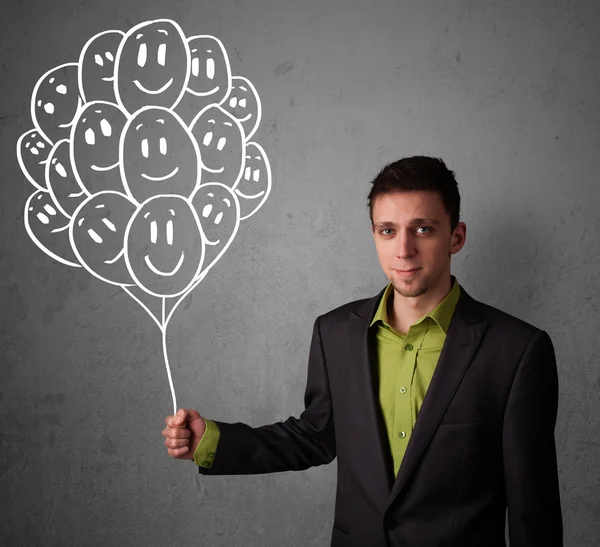 Businessman holding a bunch of smiling balloons — Stock Photo, Image