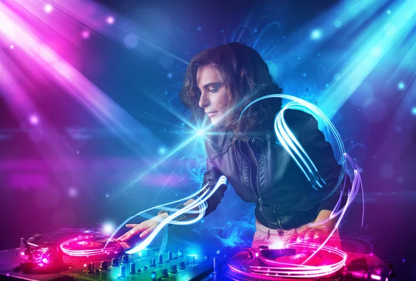 Energetic Dj girl mixing music with powerful light effects — Stock Photo, Image