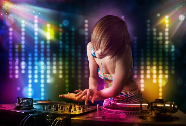 Dj ragazza che suona canzoni in una discoteca con spettacolo di luce — Foto Stock