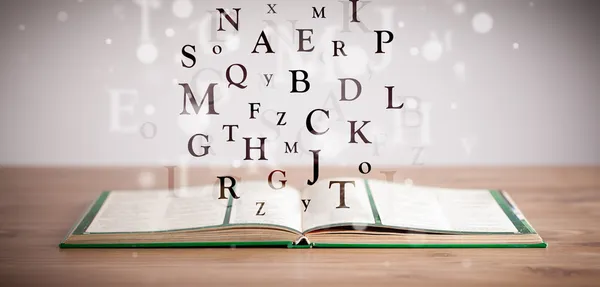 Aufgeschlagenes Buch mit fliegenden Briefen — Stockfoto