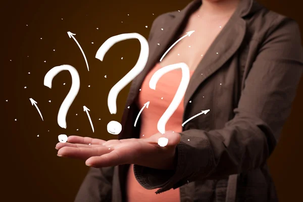 Young woman presenting hand drawn question marks — Stock Photo, Image