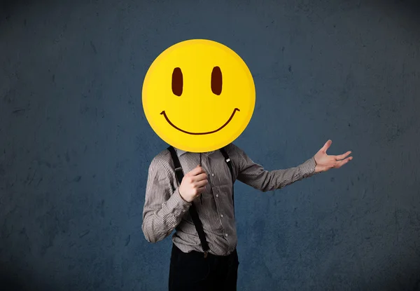 Businessman holding a smiley face emoticon — Stock Photo, Image