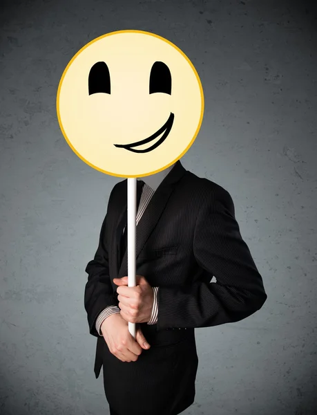 Businessman holding a smiley face emoticon — Stock Photo, Image