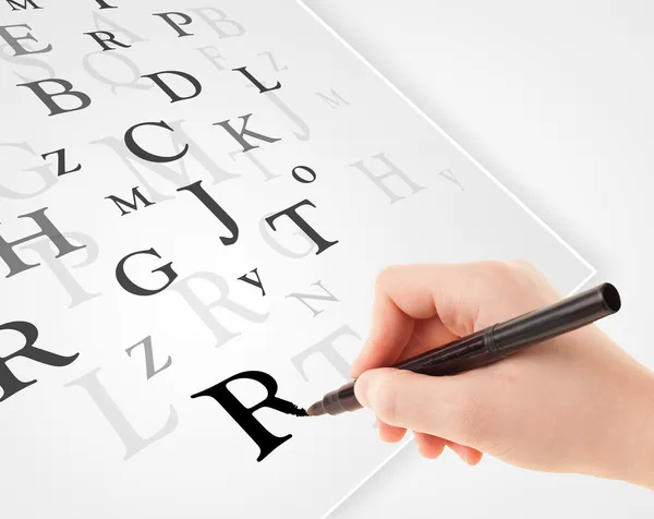 Hand skriva olika bokstäver på vitt vanligt papper — Stockfoto