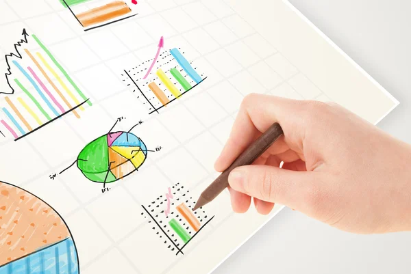 Zakelijke persoon tekening kleurrijke grafieken en pictogrammen op papier — Stockfoto