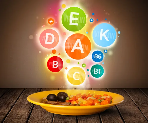 Food plate with delicious meal and healthy vitamin symbols — Stock Photo, Image