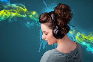 Kulaklıkla müzik dinleyen genç bir kadın.