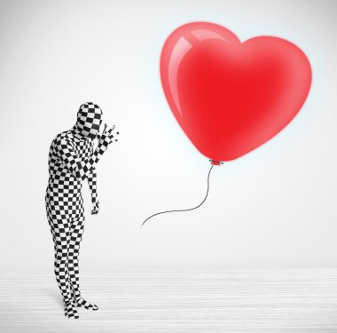 Morpsuit giyip balon şeklinde bir kalbe bakan yakışıklı bir adam.