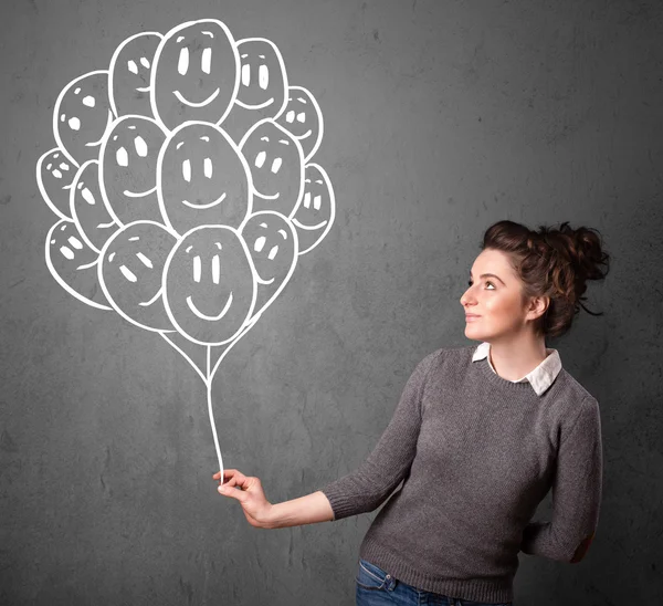 Woman holding a bunch of smiling balloons — Stock Photo, Image