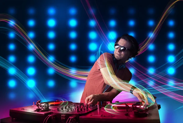 Jovem Dj misturando registros com luzes coloridas — Fotografia de Stock