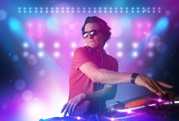 Disc jockey mixing music on turntables on stage with lights and — Stock Photo, Image