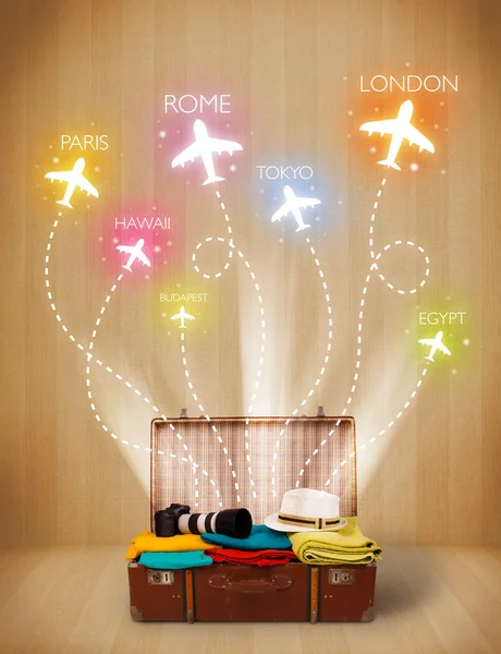 Travel bag with clothes and colorful planes flying out — Stock Photo, Image