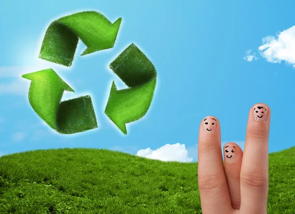 Щасливі усміхнені пальці, дивлячись на знак переробки зеленого листя — стокове фото
