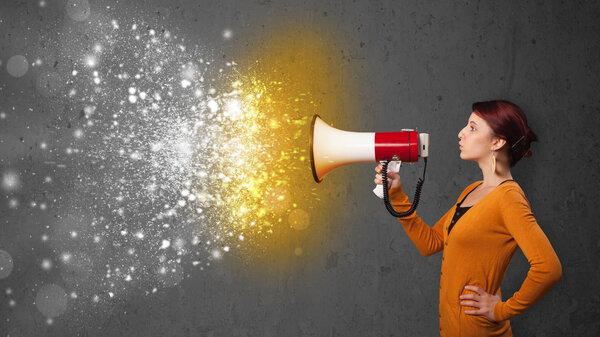Женщина кричит в мегафон и исследует светящиеся частицы энергии
