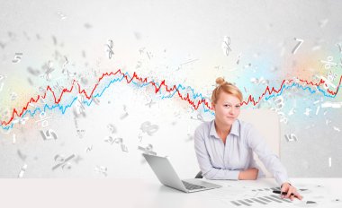 Borsa grafiğiyle masada oturan iş kadını. 