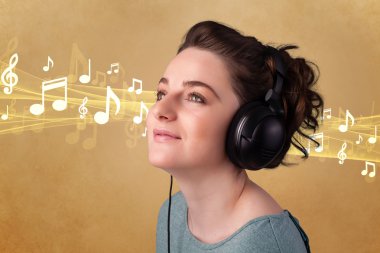 Kulaklıklı genç bir kadın müzik dinliyor.