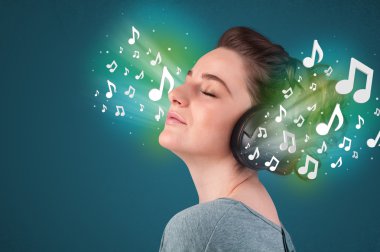 Kulaklıklı genç bir kadın müzik dinliyor.