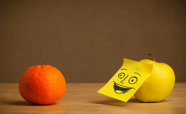 Apple with post-it note smiling at orange — Stock Photo, Image