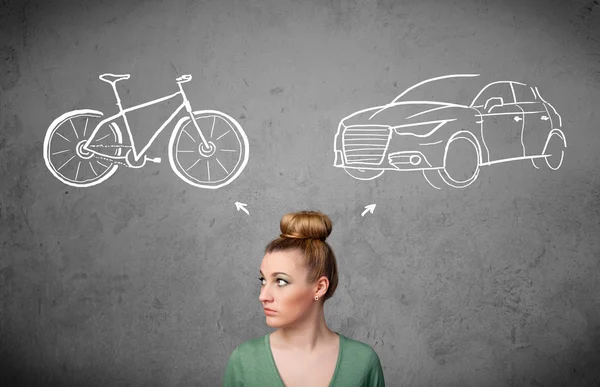 Mulher fazendo uma escolha entre bicicleta e carro — Fotografia de Stock