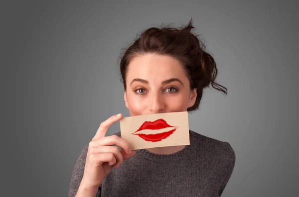 Happy pretty woman holding card with kiss lipstick mark — Stock Photo, Image