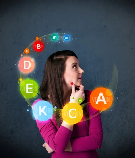 Young woman thinking with vitamins circulation around her head — Stock Photo, Image