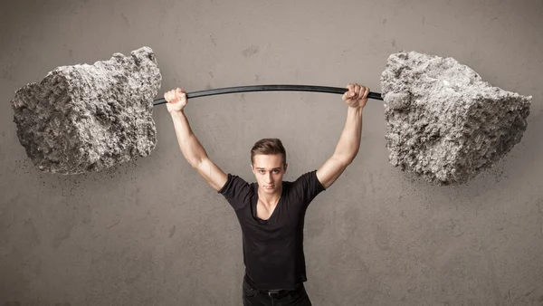 Muscular man lifting large rock stone weights — Stock Photo, Image