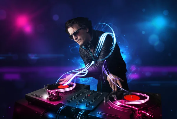 Disc jockey jouant de la musique avec des effets de lumière électro et des lumières — Photo
