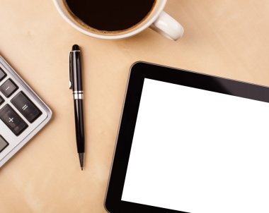 Boş alanı olan bir tablet bilgisayar ve masada bir fincan kahve.