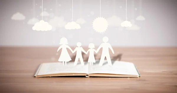 Cardboard figures of the family on opened book — Stock Photo, Image