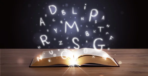 Open book with glowing letters flying out — Stock Photo, Image