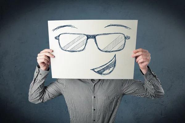 Homme d'affaires tenant un papier avec le visage souriant devant sa hée — Photo