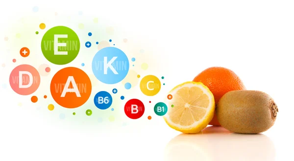Здоровые фрукты с красочными витаминными символами и иконами — стоковое фото