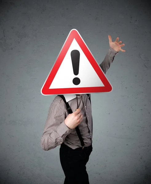 Businessman holding an exclamation road sign — Stock Photo, Image