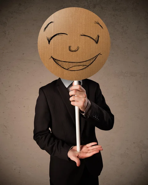 Businessman holding a smiley face board — Stock Photo, Image