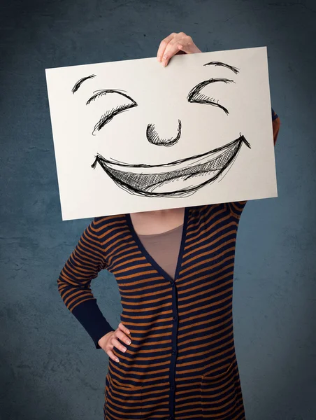 Woman with drawed smiley face on a paper in front of her head — Stock Photo, Image