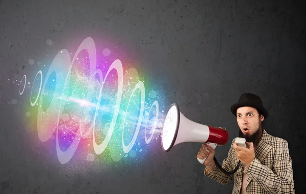 Man yells into a loudspeaker and colorful energy beam comes out — Stock Photo, Image