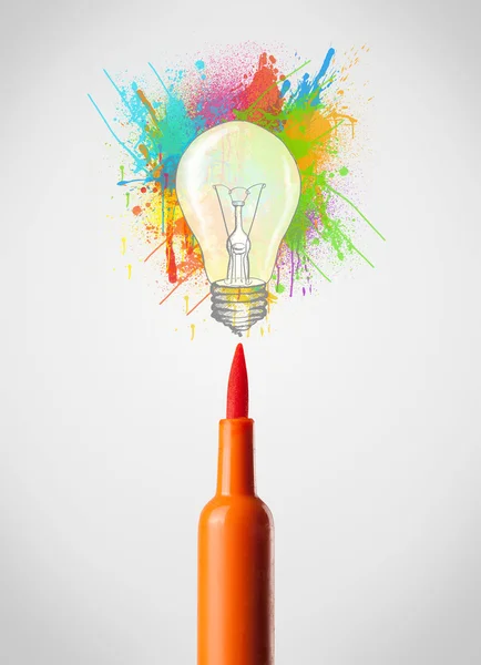 Фелтовая ручка крупным планом с цветными брызгами краски и лампочкой — стоковое фото