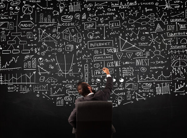 Бизнесмен сидит перед доской с картами