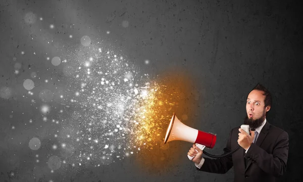 Guy shouting into megaphone and glowing energy particles explode — Stock Photo, Image