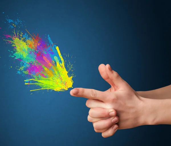 Colorful splashes are coming out of gun shaped hands — Stock Photo, Image