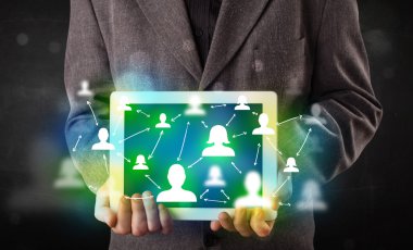 Yeşil sosyal medya simgeleriyle tablet sunan genç kişi