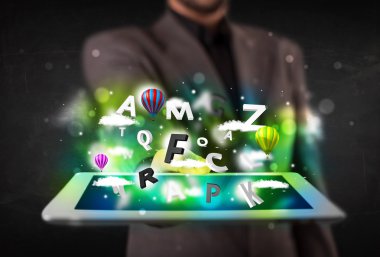 Tableti soyut harflerle ve gökyüzüyle gösteren genç kişi