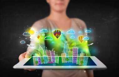 Elle çizilmiş şehir manzaralı tablet gösteren genç kişi