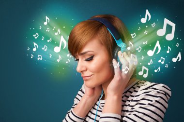 Kulaklıklı genç bir kadın müzik dinliyor.