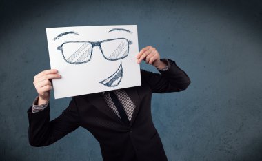 bir kağıt ile gülen yüz onun hea önünde tutan işadamı