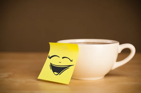 Post-it note avec le visage souriant collé sur la tasse — Photo