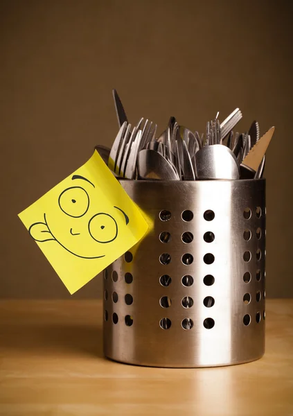 Post-it-Zettel mit Smiley-Gesicht auf Bestecketui geklebt — Stockfoto