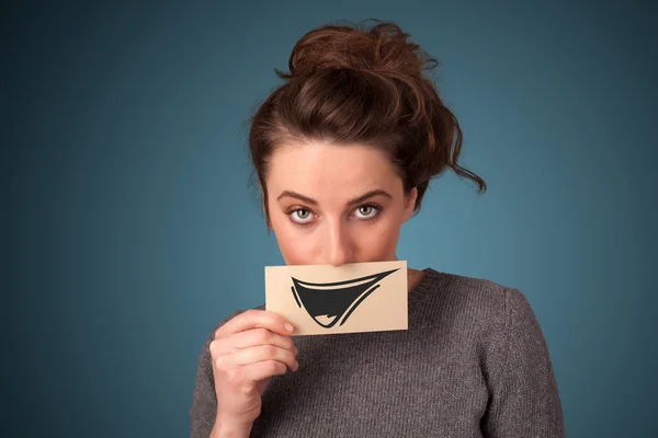 Feliz bonito menina segurando papel com engraçado smiley desenho — Fotografia de Stock