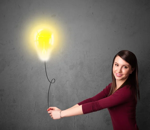 Donna in possesso di un palloncino lampadina — Foto Stock