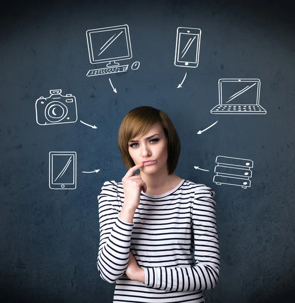 Jeune femme pensant avec des gadgets dessinés autour de sa tête — Photo